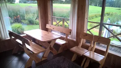 a wooden table and two chairs in front of a window at Mikalojiškis in Inturkė