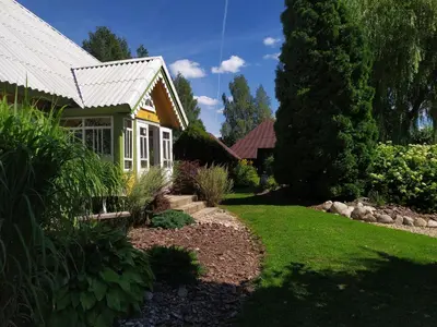 a garden with a house and a yard with grass at Kačiūniškis in Kaciūniškiai
