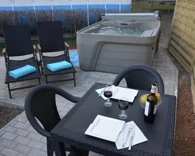 a table with two chairs and a hot tub at Apartments with outdoor SPA jacuzzi and sauna in Vilnius