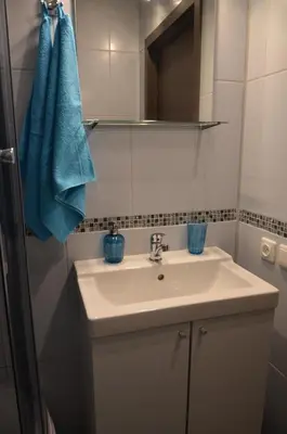 a bathroom with a sink and a blue towel at Apartments with outdoor SPA jacuzzi and sauna in Vilnius
