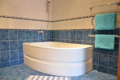 a white tub in a bathroom with blue tiles at Apartments with outdoor SPA jacuzzi and sauna in Vilnius