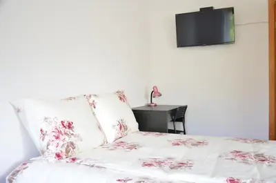 a bedroom with a bed with a tv on the wall at Apartments with outdoor SPA jacuzzi and sauna in Vilnius