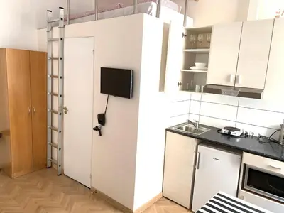 a kitchen with white cabinets and a door at Centro apartment near Gedimas Avenue in Vilnius