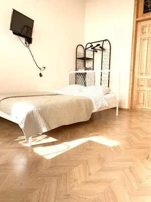 a white bed in a room with a wooden floor at Centro apartment near Gedimas Avenue in Vilnius