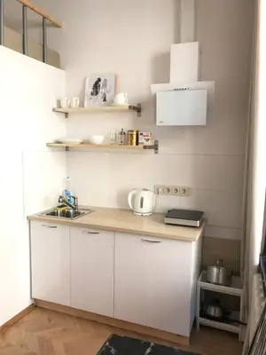 a small kitchen with white cabinets and a sink at Centro apartment near Gedimas Avenue in Vilnius