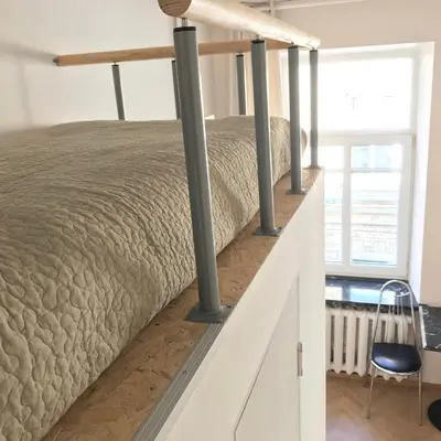 a bed on the top of a staircase in a room at Centro apartment near Gedimas Avenue in Vilnius
