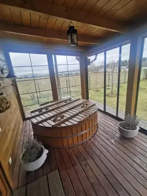 a wooden deck with a circular seating area on a porch at Arturas Guest House in Vilnius