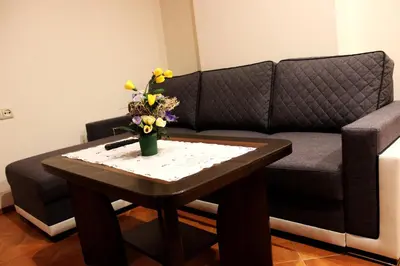 a living room with a couch and a table with flowers at Vidų Guest House in Utena