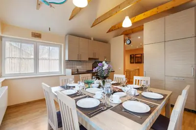 a dining room with a wooden table and chairs at Vila Liepa in Birštonas