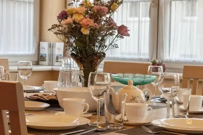 a table with a vase of flowers on it at Vila Liepa in Birštonas