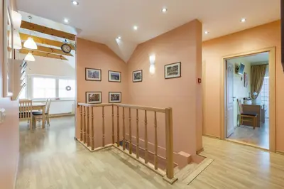 a living room with a staircase and a dining room at Vila Liepa in Birštonas