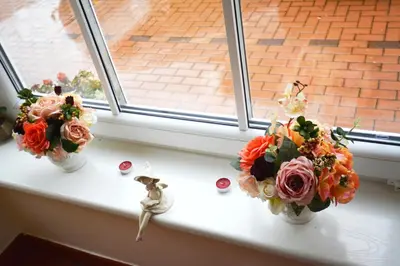 two vases filled with flowers sitting on a window sill at Vila Liepa in Birštonas