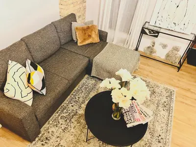 a living room with a couch and a table with flowers at Tomy Old Town Apartments in Vilnius