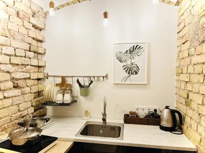 a kitchen with a sink and a brick wall at Tomy Old Town Apartments in Vilnius