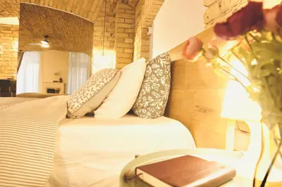 a bedroom with a bed with pillows and a vase of flowers at Tomy Old Town Apartments in Vilnius