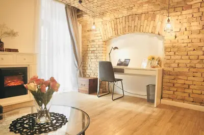 a living room with a glass table and a brick wall at Tomy Old Town Apartments in Vilnius