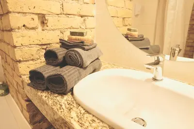 a bathroom with a sink and a mirror and towels at Tomy Old Town Apartments in Vilnius