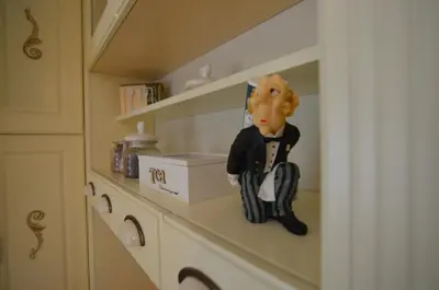 a doll is sitting on a shelf in a kitchen at Broadway apartament in Šiauliai