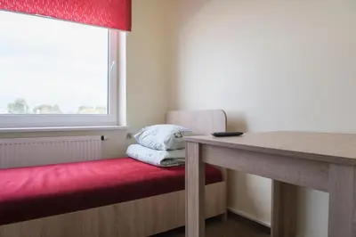 a room with a bench and a table and a window at Hostelis Laurita in Kaunas
