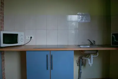 a kitchen counter with a microwave and a sink at Hostelis Laurita in Kaunas