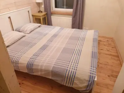 a bed with a blue and white comforter in a room at Igo Apartment Townhall in Vilnius