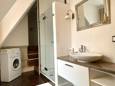 a bathroom with a sink and a washing machine at Very Vilnius Pilies street in Vilnius