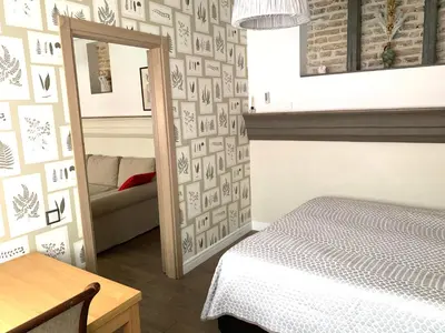 a bedroom with a mirror and a bed and a couch at Very Vilnius Pilies street in Vilnius