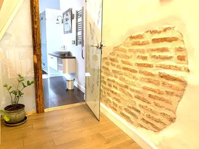a bathroom with a stone wall with a doorway at Very Vilnius Pilies street in Vilnius