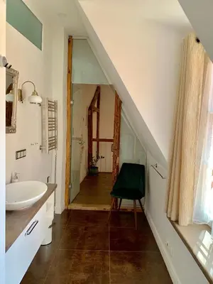an attic bathroom with a sink and a mirror at Very Vilnius Pilies street in Vilnius