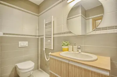 a bathroom with a sink and a toilet and a mirror at Apartamentai Liuks in Druskininkai