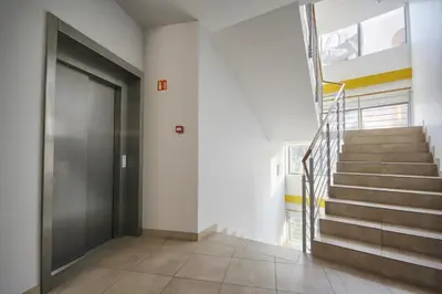 a hallway with a door and stairs in a house at Apartamentai Liuks in Druskininkai