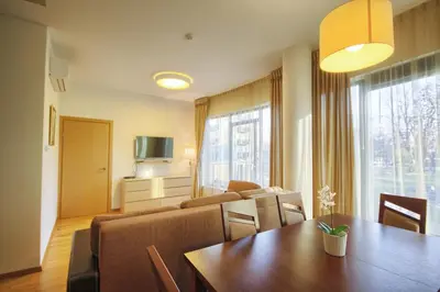 a room with a dining table and a living room at Apartamentai Liuks in Druskininkai