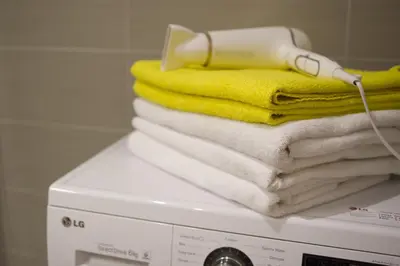 a stack of towels on top of a washing machine at Apartamentai Liuks in Druskininkai