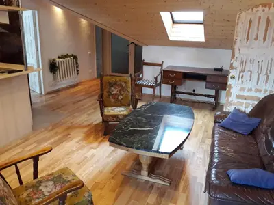 a living room with a table and a piano at Vilnius Luxury Apartment 2 in Vilnius