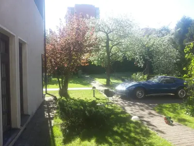 a blue car parked in a yard next to a building at Vilnius Luxury Apartment 2 in Vilnius