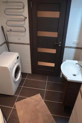 a bathroom with a washing machine and a sink at Apartments Ozo Park in Vilnius
