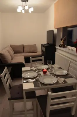 a living room with a table and a couch at Apartments Ozo Park in Vilnius