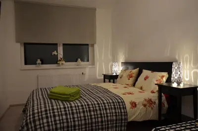 a bedroom with a bed with a green towel on it at Apartments Ozo Park in Vilnius