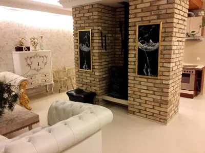 a living room with a white couch and a brick wall at Vilnius Luxury Apartment 3 in Vilnius