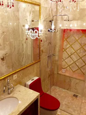 a bathroom with a red toilet sitting next to a sink at Luxury Pilies Avenue Apartment in Vilnius
