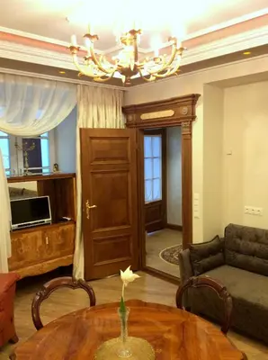 a living room with a table and a chandelier at Luxury Pilies Avenue Apartment in Vilnius