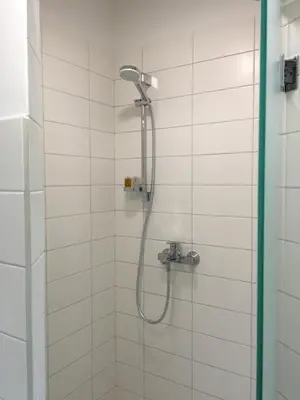 a shower with a shower head in a bathroom at Inga Vacation House in Druskininkai