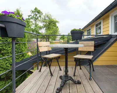a patio table and two chairs on a deck at Inga Vacation House in Druskininkai