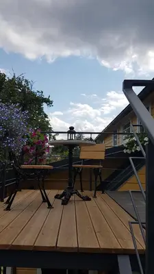 a wooden deck with a table and a bench on it at Inga Vacation House in Druskininkai