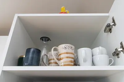 a shelf with cups and mugs on it at Vilnius Old Town Happiness in Vilnius
