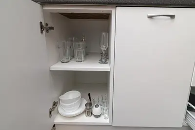 a cupboard filled with dishes and glasses at Vilnius Old Town Happiness in Vilnius