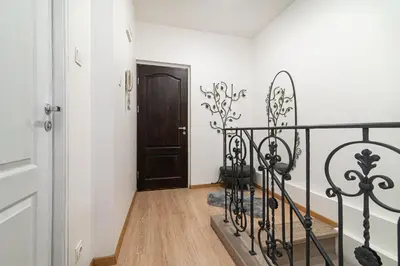 a hallway with a black railing and a door at Vilnius Old Town Happiness in Vilnius