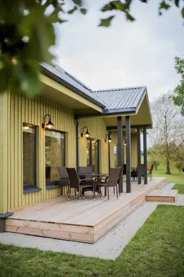 a deck with chairs and tables on a house at Aitvaras in Anykščiai