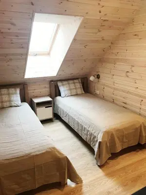 a attic bedroom with two beds and a window at Aitvaras in Anykščiai