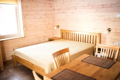 a bedroom with a bed and a table in a room at Aitvaras in Anykščiai